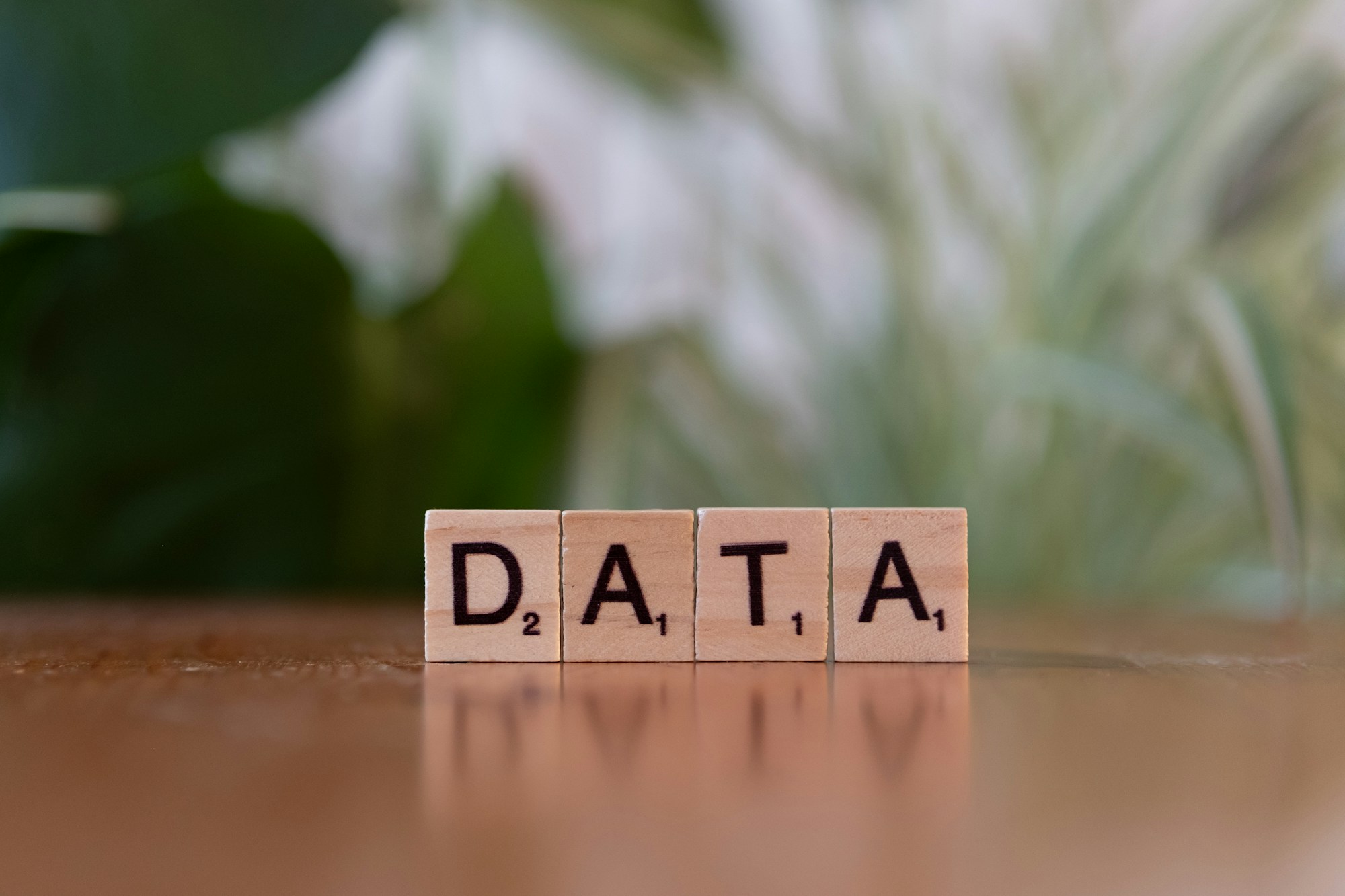 Trebokstaver som staver ordet DATA på et skrivebord - illustrasjon for behandling av personopplysninger