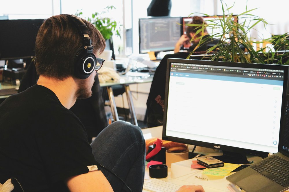 IT technician helping a colleague with a computer problem at their workstation